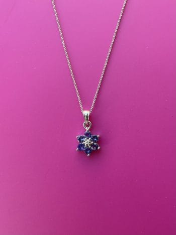 Pretty vintage flower pendant in 9ct white gold set with tanzanite and center diamond. in perfect condition 1cm across flower