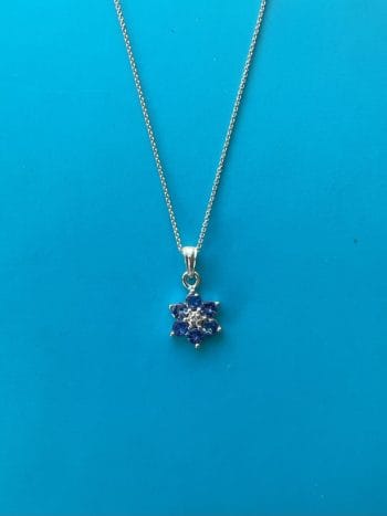 Pretty vintage flower pendant in 9ct white gold set with tanzanite and center diamond. in perfect condition